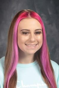 student with longer hair and white shirt