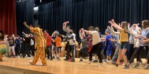 student dancing on stage to african music