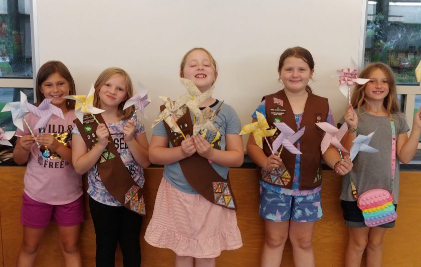 five members of Brownies hold pinwheels they made in their hands