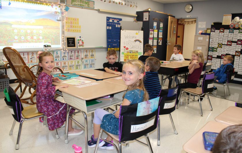 students turning around from thier chairs to smile at camera