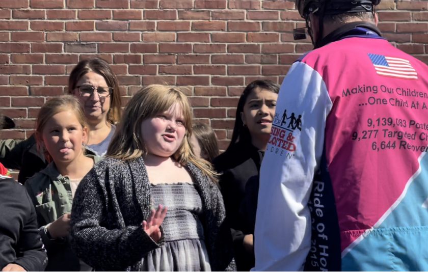 one student talking to cyclist and other looking interested at him
