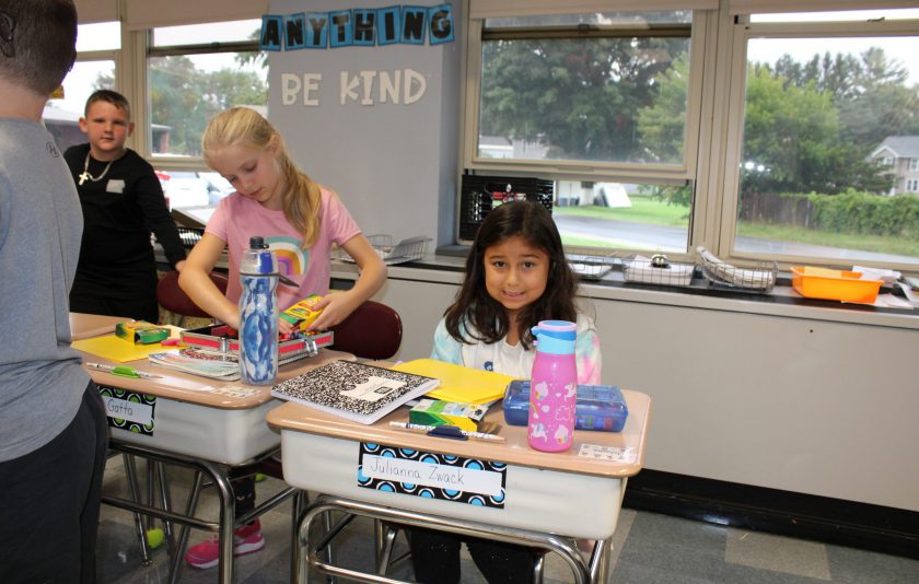 student with colorful folders on her desk