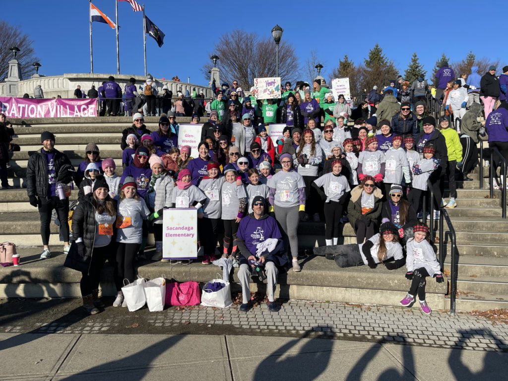 a huge group of runners holding signs standing outside 