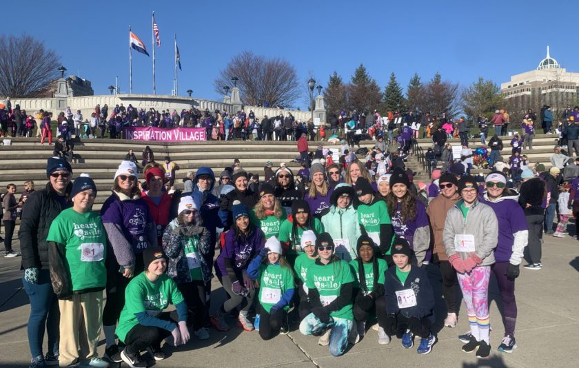 group of middle school students and adults, most are dressed in green