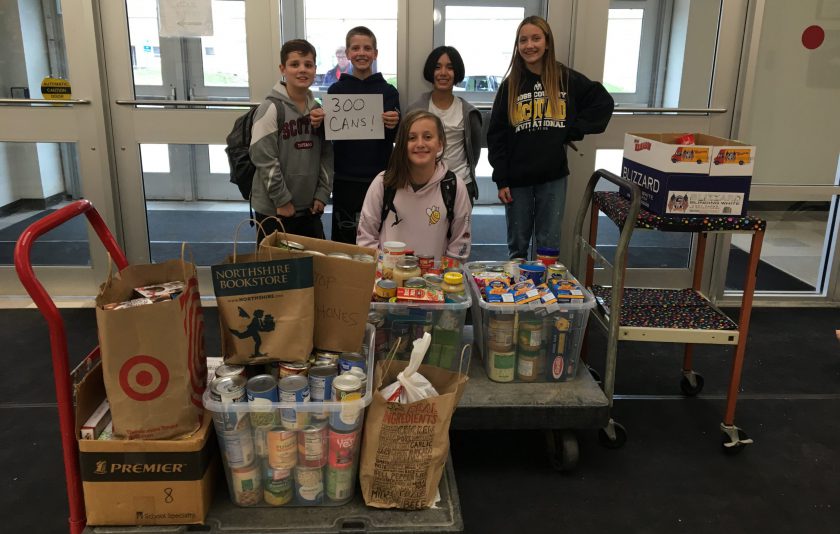 five students standing behind canned food items