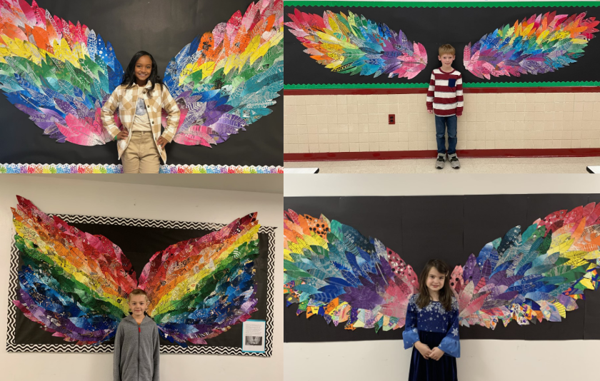 four students standing in front of colorful wings made of feathers