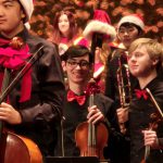 student wearing a bowtie and holding a violin in the orchestra 