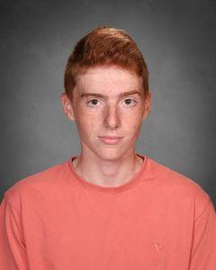 student with red hair wearing an orange shirt