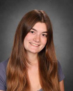 student with brown hair split down the middle with head tilted