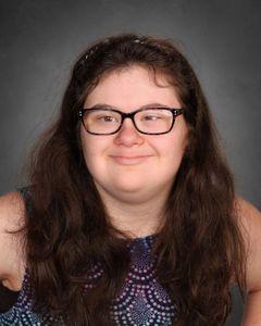 student with small dark rimmed glasses wearing sleeveless shirt