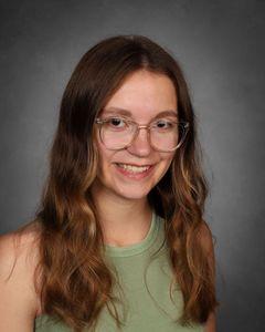 student with long wavy hair and glasses