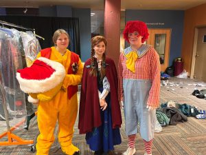 three students dressed in costumes: Pikachu, Harry Potter, and Raggedy Andy 