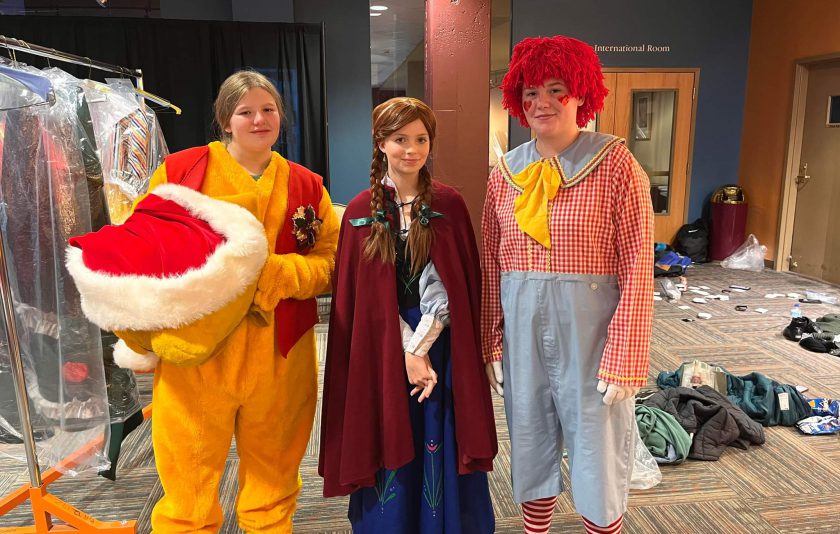 three students dressed in costumes: Pikachu, Harry Potter, and Raggedy Andy