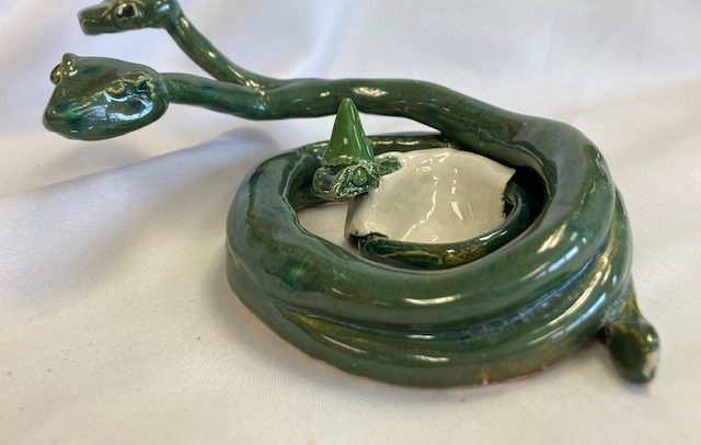 a green ceramic snake with three heads
