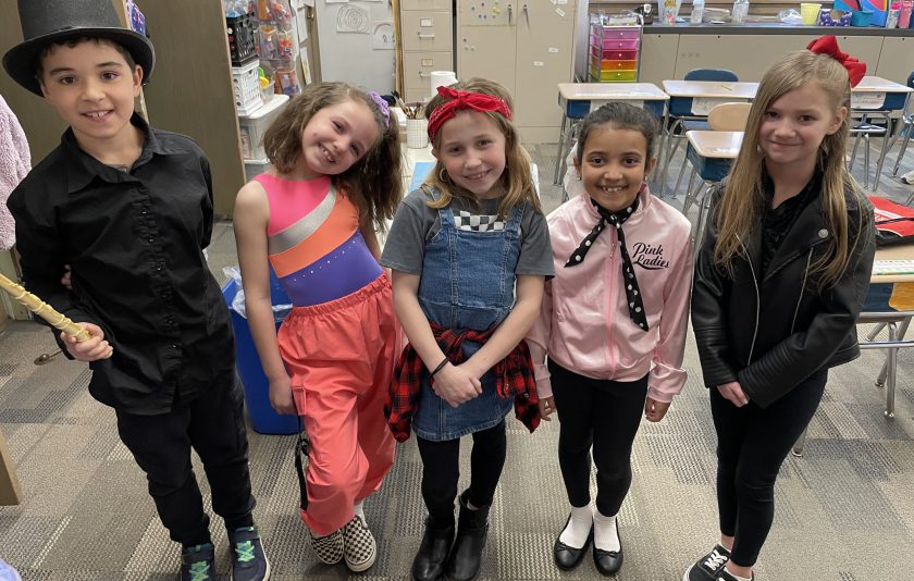 five young students dressed in costumes