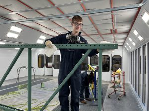 student working with green metal