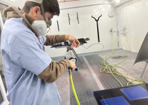 student wearing a mask and working with power tools