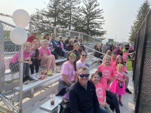 teachers, parents and students on bleachers at softball game