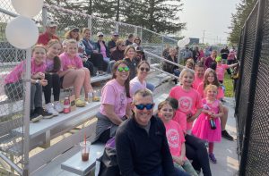 teachers, parents and students on bleachers at softball game
