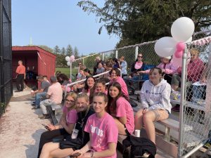 students sitting on bleachers and most are wearing pink