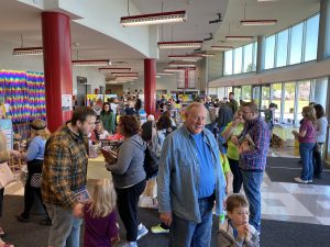 many people, young and older, standing in a library