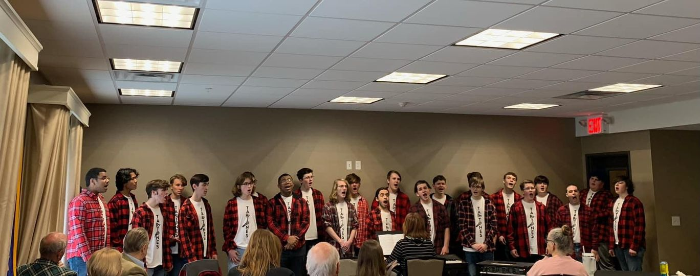 students standing in a line all wearing black and red flannel shirts