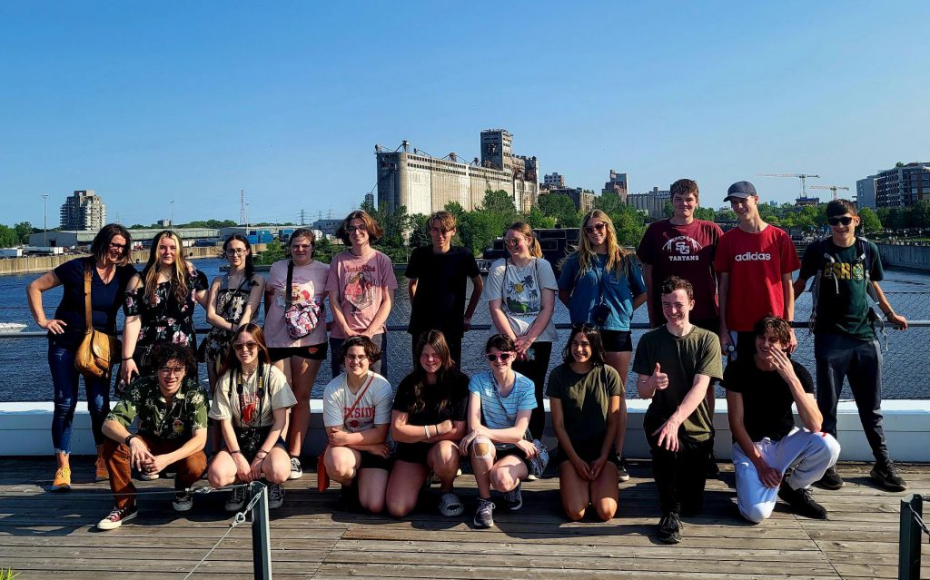 Group of students pose on bridge