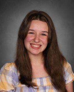 Student with long brown hair smiling at camera 