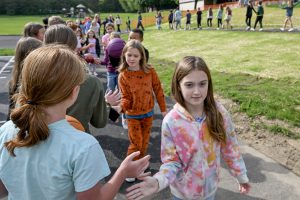 girl in fron high fives other students and others in line all do the same thing