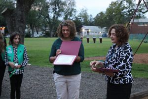two women holding certificates to present to line of girl scouts