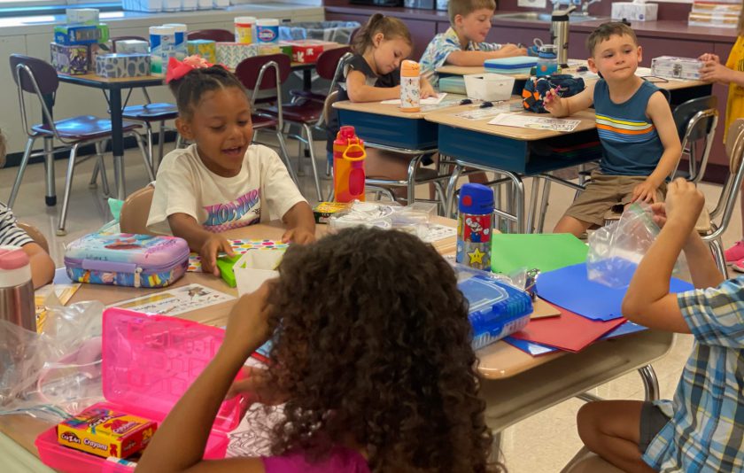 students sitting at tables doing activities