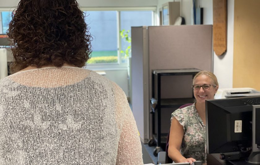 woman greeting superintendent behind desk in office