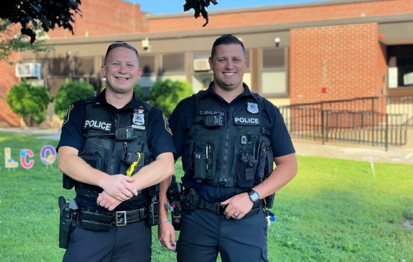 two officers outside school to greet students