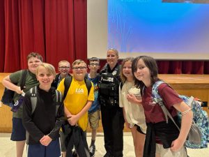 seven students stand with SRO at assembly