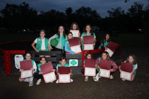 students standing inside and out of the gaga pit holding their certificates