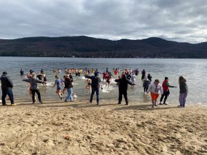 students running into Lake George and running out of the water too