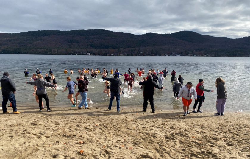 students running into Lake George and running out of the water too