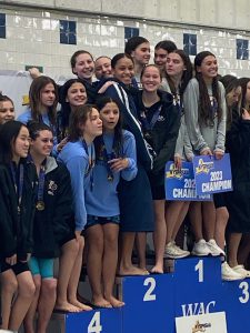 swimmers standing on their winning blocks after event