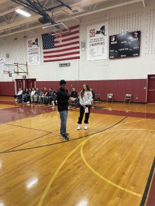two students presenting a message in the gym