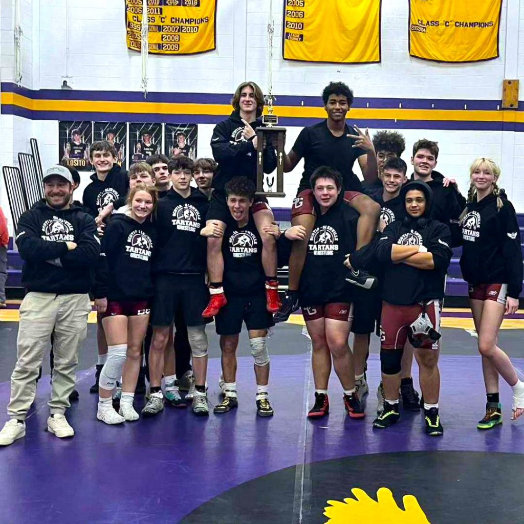 wrestling team standing on matts after their win