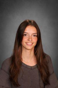 student with dark long hair smiles