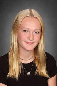 student with long blonde hair smiles