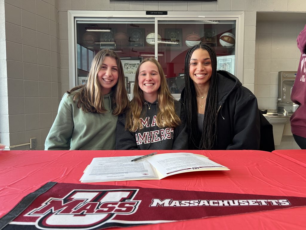 three students sitting together smiling