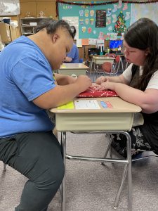 two students wrapping a gift