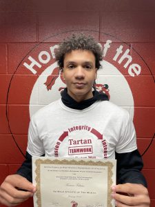 student smiling while holding up a certificate