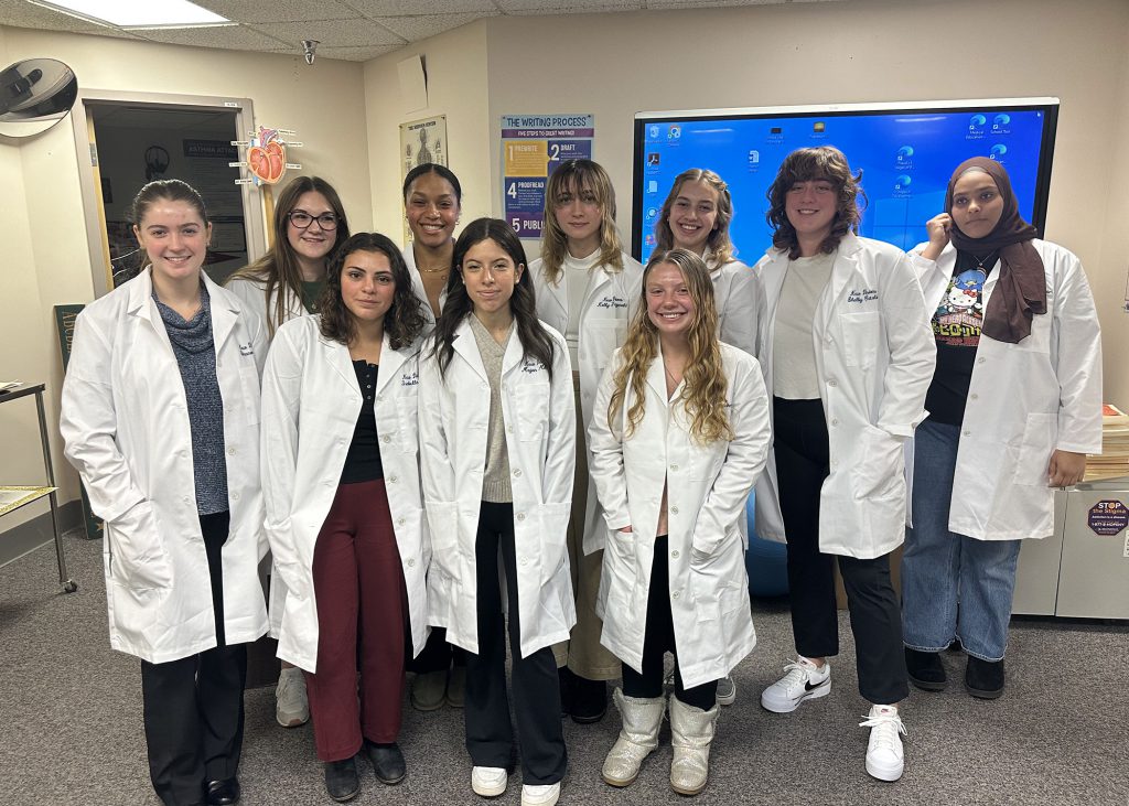 students studying medical careers wearing white coats