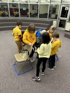 kids wearing yellow sweatshirts huddled together 