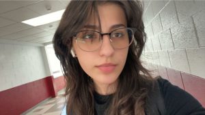 student with dark choppy hair wearing glasses