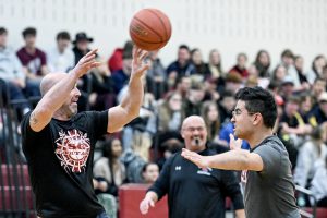 teacher with basketball and student guards him