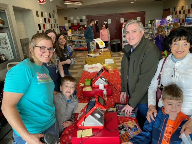 families at cash register buying books